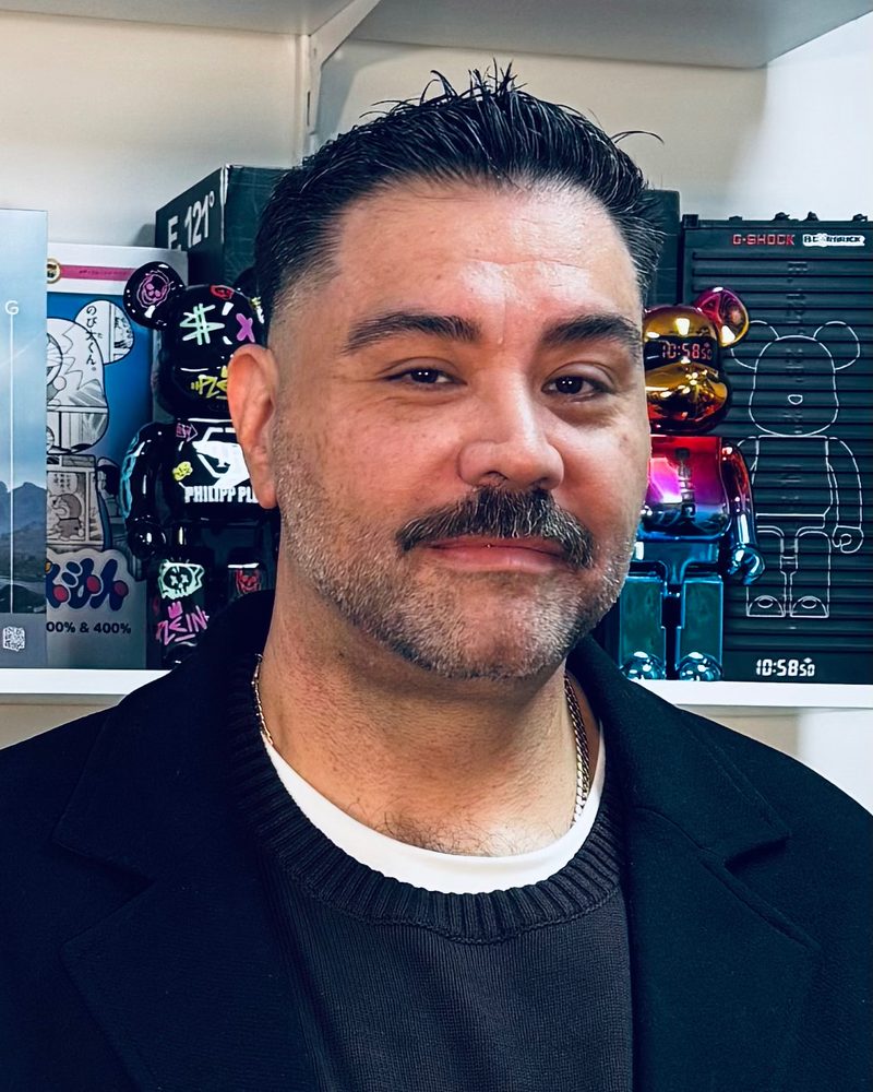 Jonathan Marin CVAu, collectibles valuer, in front of a shelf of designer art toys